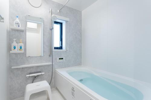 a bathroom with a tub and a toilet and a sink at Shinjuku City House - Vacation STAY 15772 in Tokyo