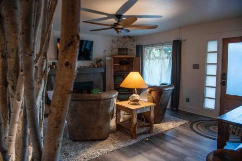 uma sala de estar com uma ventoinha de tecto e uma mesa em Assist the Bliss - SPA, Firesides, Griddle bbq em Twin Falls