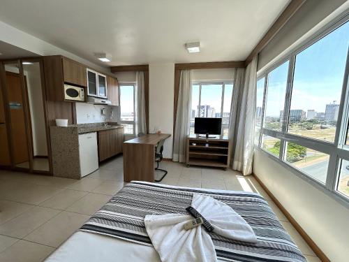 um quarto com uma cama e uma grande janela em SM622 Flat região central Próx Embaixada Americana em Brasília