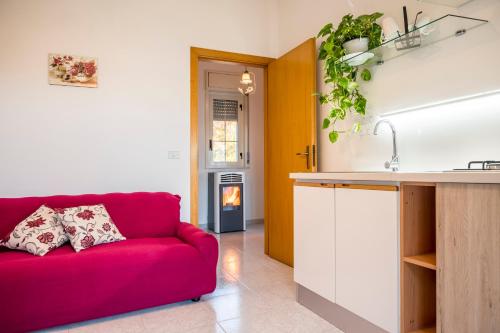 un salon avec un canapé rouge dans une cuisine dans l'établissement Valateddi, à Cammarata