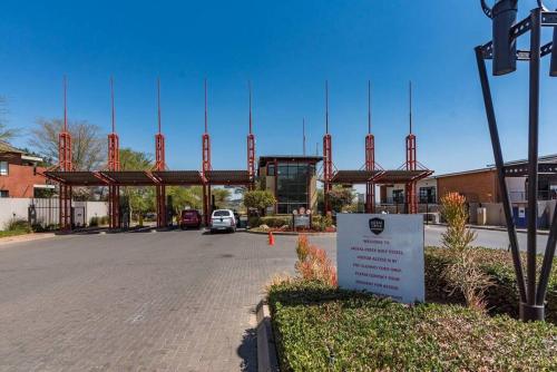 a parking lot in front of a building with a sign at 1 Bed Apartment @ Jackal Creek Golf Estate in Roodepoort