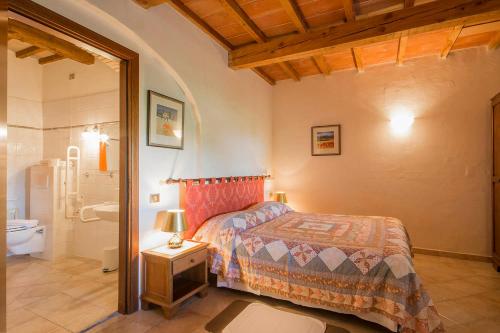 a bedroom with a bed and a bathroom at Le Valli Tuscany in Pomarance