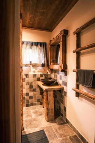a bathroom with a sink and a tiled floor at Little Trees Apartment in Benecko