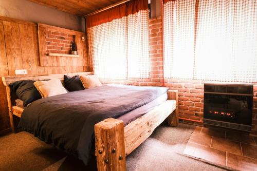 1 dormitorio con 1 cama con chimenea y ventana en Little Trees Apartment, en Benecko