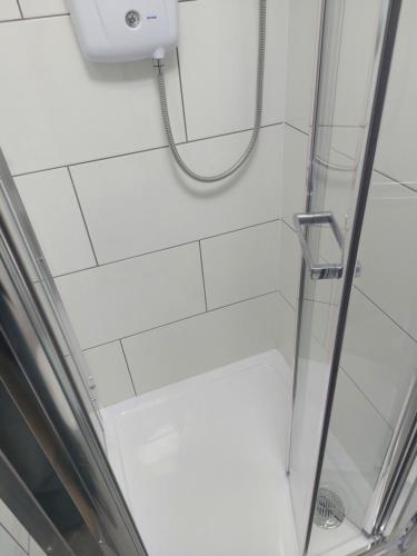 a shower with a glass door and a shower at De lick strawberry studio in London