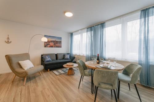 a living room with a table and chairs and a couch at Modernes 2-Zimmer Themen-Apartment "Heimathafen" im Zentrum in Bayreuth