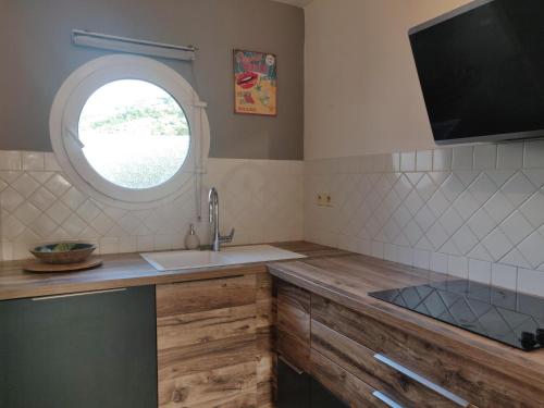 a kitchen with a sink and a window at La Terrasse in Le Carbet