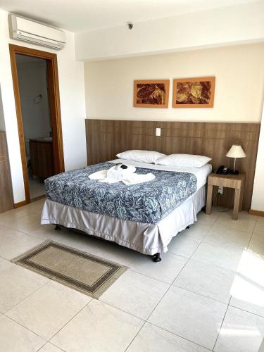 a bedroom with a large bed with a blue blanket at SM504 Apart Hotel próximo a Esplanada in Brasilia