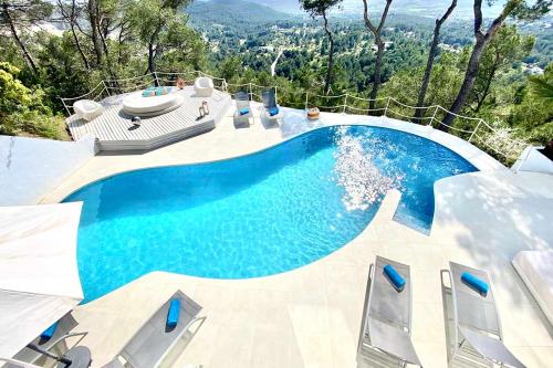 einen Pool mit blauem Wasser im Hinterhof in der Unterkunft Villa with Amazing views over the Hill in Can Furnet
