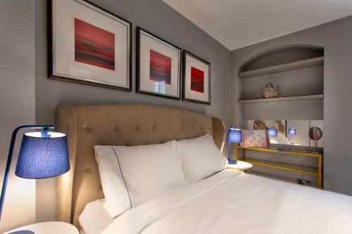 a bedroom with a white bed and some pictures on the wall at THE PAD at Sloane Square in London