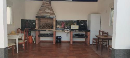 a room with a table and some chairs and a table and a table at Casa rural con piscina climatizada y barbacoa a 10 km de Alicante y playas, 3000 m2 de terreno in Elche