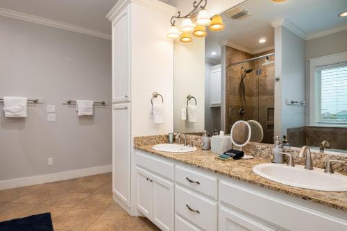 un bagno con due lavandini e un grande specchio di The Lone Palm Resort a Bolivar Peninsula