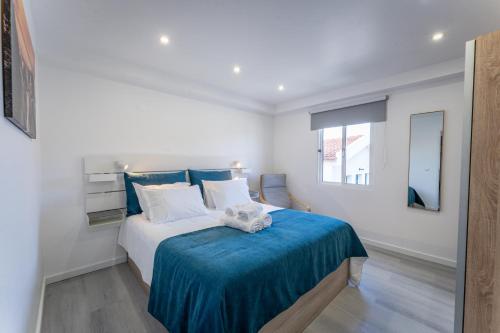 een slaapkamer met een bed met een blauwe deken bij Ocean Breeze in Porto Moniz