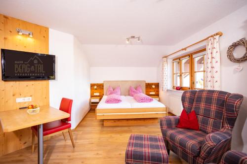 una camera da letto con un letto, un divano e una sedia di Haus Berg & Tal a Hirschegg
