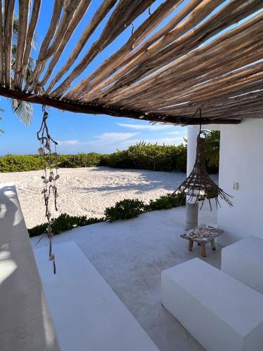 a pavilion with a bench under a straw roof at Casa Almea Sisal in Sisal