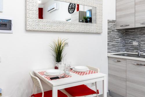 a white kitchen with a table and a sink at DUOMO-Sesto M1 Relax Campari Wi-fi & Netflix in Sesto San Giovanni