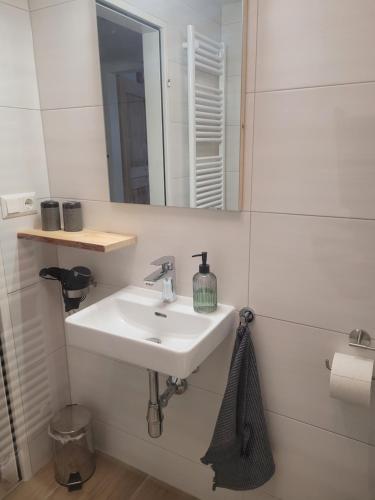 a white bathroom with a sink and a mirror at Apartmenthaus Edelweiss in Gosau in Gosau