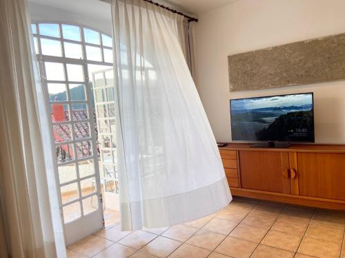 a living room with a television and a sliding glass door at Piso en Vall de Almonacid con vistas, aire acondicionado, Wifi y Smart TV in Vall de Almonacid