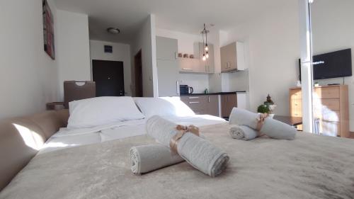 a bedroom with two towels on a bed at Allurian Apartment - City kvart in Podgorica