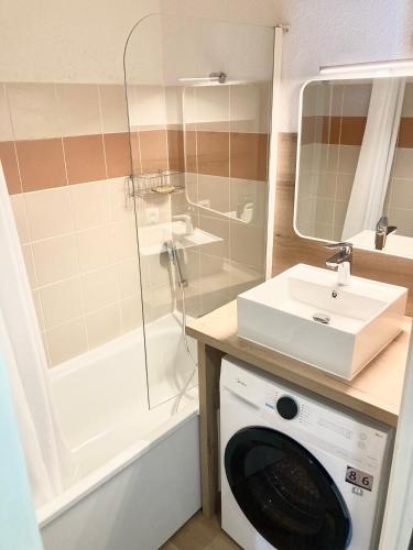 une salle de bain avec une machine à laver et un lavabo dans l'établissement Tout confort sur les pistes, à Saint-François-Longchamp