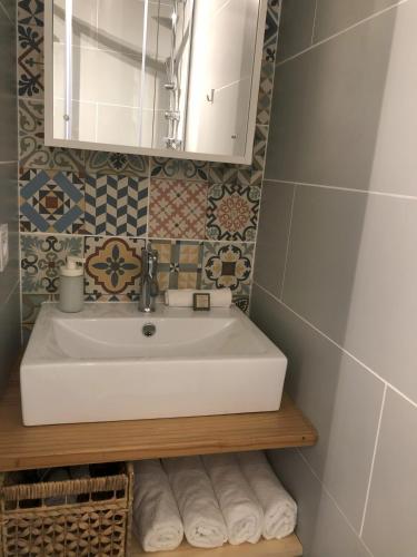 une salle de bain avec un lavabo, un miroir et des serviettes dans l'établissement Charmant appartement à flanc de montagne, à Barèges