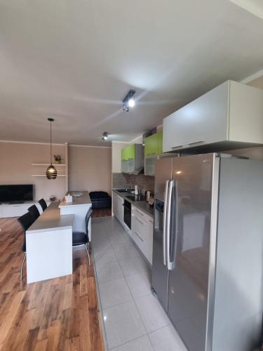 a kitchen with a stainless steel refrigerator and a table at Hawaii- 2 bdr, Arena, Sava centar, FREE PARKING in Novi Beograd