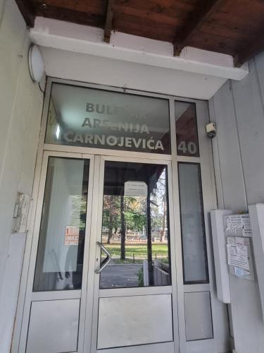 a door to a building with a sign on it at Hawaii- 2 bdr, Arena, Sava centar, FREE PARKING in Novi Beograd