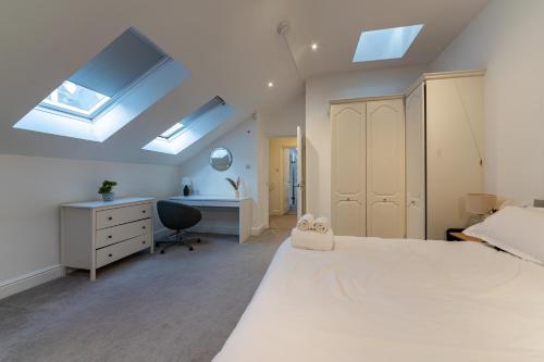 a bedroom with a bed and a desk and skylights at Abbey Rd - St John's Wood Retreat by Aureva in London