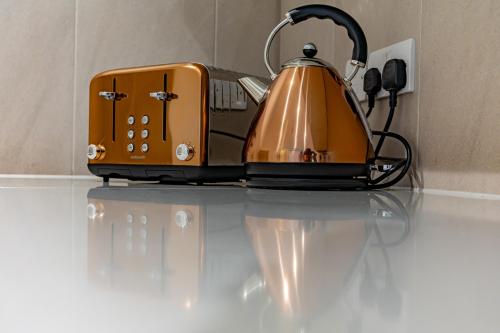 an orange toaster sitting on top of a counter at Abbey Rd - St John's Wood Retreat by Aureva in London