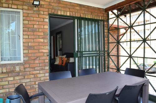 a table and chairs in front of a brick wall at Soldout Camp 2 in Pretoria