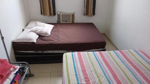 1 dormitorio pequeño con 2 camas en una habitación en Hospedagem Reserva da Praia, en Recreio dos Bandeirantes