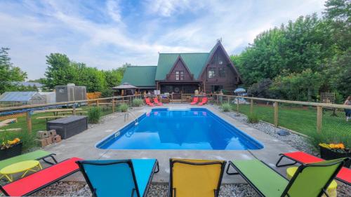 Una piscina frente a una casa con sillas alrededor. en The Lodge at Lakeshore, en Belle River