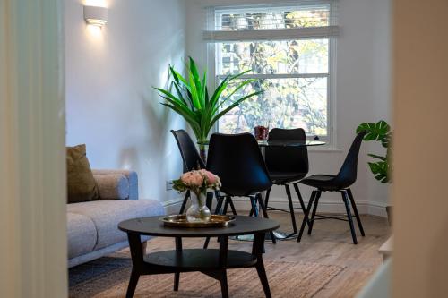 un soggiorno con tavolo e sedie di Stylish LUXE 4Beds Abbey Rd St Johns Wood a Londra