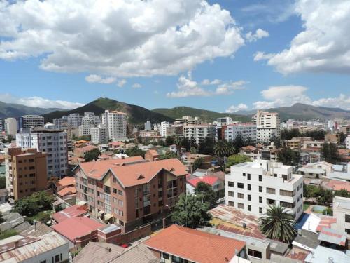 uma cidade com edifícios e montanhas ao fundo em Cómodo monoambiente en El Prado em Cochabamba