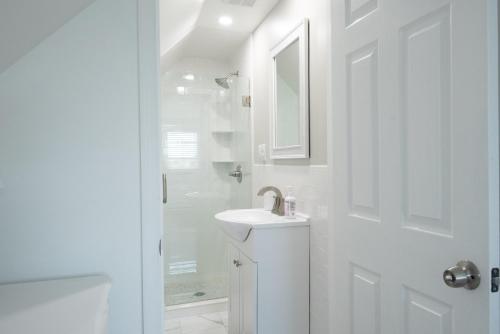 a white bathroom with a sink and a shower at The Wren's Nest in Birdsboro