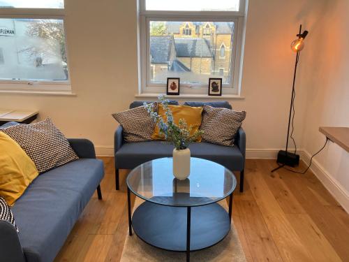 uma sala de estar com dois sofás e uma mesa de vidro em Awesome Refurbished 1 Bed Flat few steps to High St ! - 2 East House em Epsom