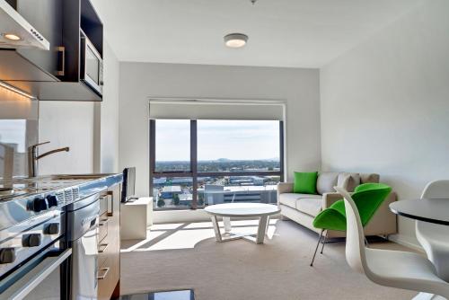 a kitchen and living room with a couch and a table at MCentral Apartments Manukau in Auckland