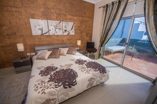 a bedroom with a bed and a large window at Francis Flats Modern Penthouse in Mellieħa