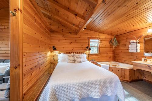 a bedroom with a bed in a wooden cabin at Arrowhead Cabin/Fields of Home in Millersburg