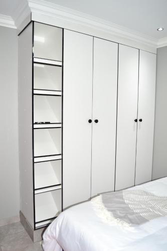 a bedroom with white cabinets and a bed at Soldout Camp 2 in Pretoria