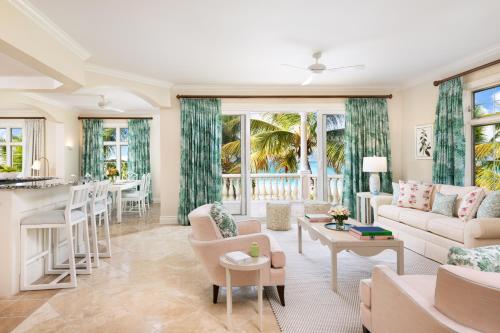 a living room with a couch and a table at Point Grace in Grace Bay