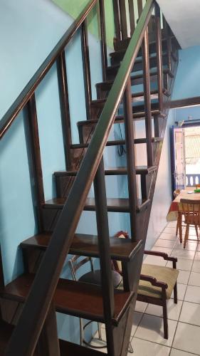 a wooden spiral staircase in a room with windows at Apto de 6a8 Pessoas a 50m Praia aceita Pets in Cidreira