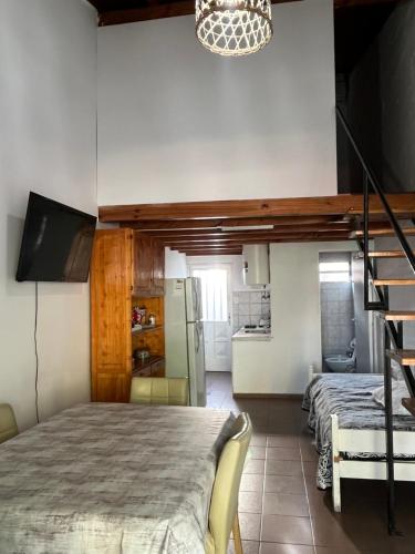 a bedroom with a loft bed and a kitchen at Depto céntrico General Alvear in General Alvear