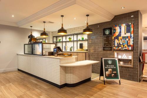 a fast food restaurant with a counter with a sign at Holiday Inn - Glasgow Airport by IHG in Paisley