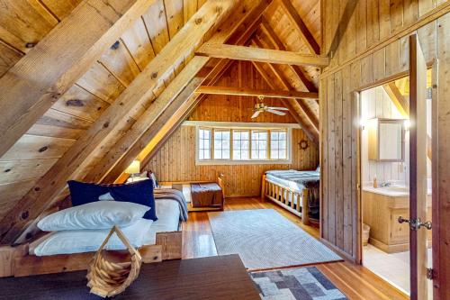 een slaapkamer in een blokhut met een bed en een wastafel bij Piney Bear Cabin in Swanton