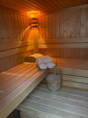 a sauna with two towels and a bucket in it at Modernes Apartment mit Whirlpool & Gartensauna in Geisenheim