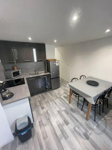 une cuisine avec une table et des chaises dans une pièce dans l'établissement Appartement Type 3 La Ciotat, à La Ciotat