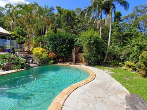 a swimming pool in a yard with a landscaping at Healing Garden Retreat Tallebudgera Valley "The Uluwatu" in Gold Coast