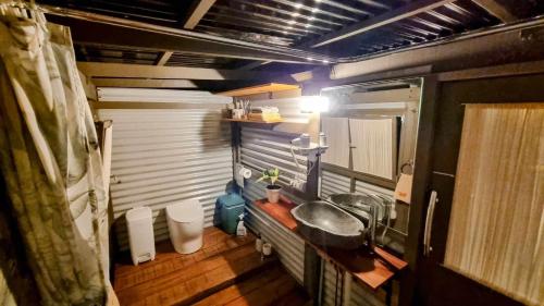 una pequeña cocina con fregadero en un remolque en Healing Garden Retreat - Uluwatu, en Gold Coast
