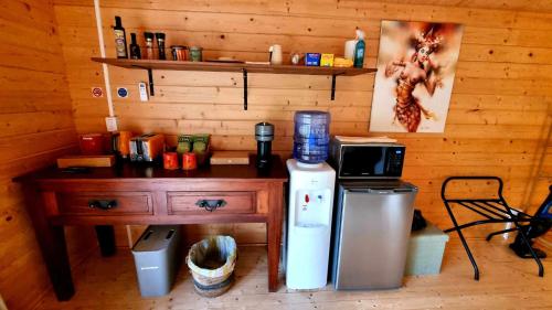 a kitchen with a wooden wall with a table and a microwave at Healing Garden Retreat Tallebudgera Valley "The Uluwatu" in Gold Coast